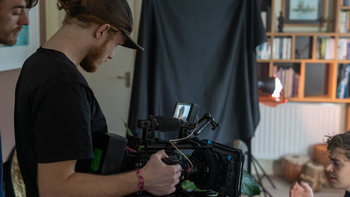 Criador de conteúdo trabalhando em múltiplos clipes de vídeo em formato curto com ferramentas de clonagem de voz com IA visíveis no fluxo de produção — Foto de Ben Collins no Unsplash