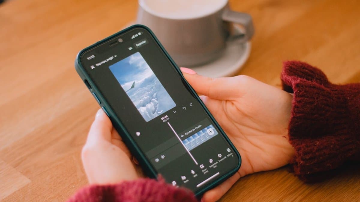 Creador de contenido trabajando con línea de tiempo de edición de video multisecuencia en dispositivo móvil durante producción de video de formato corto — Foto de Swello en Unsplash