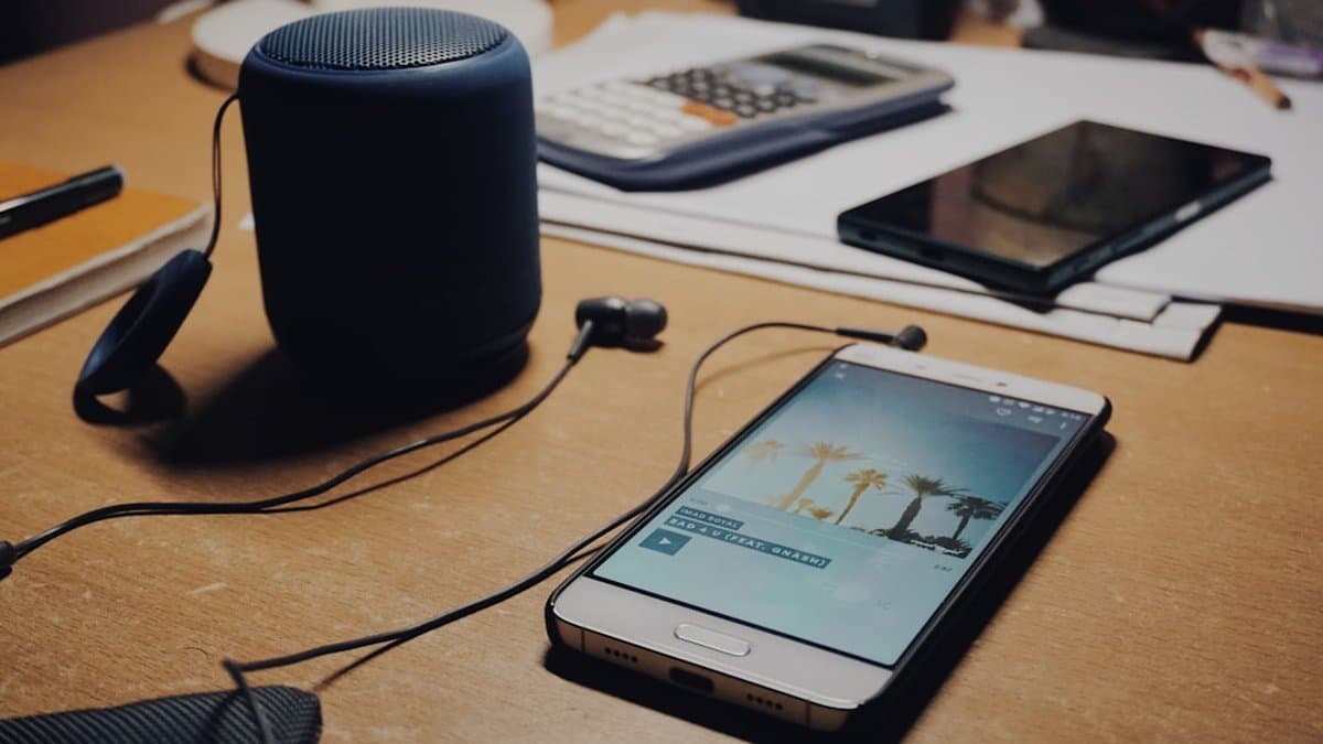 Smartphone with audio waves demonstrating how sound frequencies translate on mobile speakers compared to studio-quality audio monitoring — Photo by Shuvro Mojumder on Unsplash